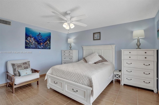 bedroom with ceiling fan and a textured ceiling