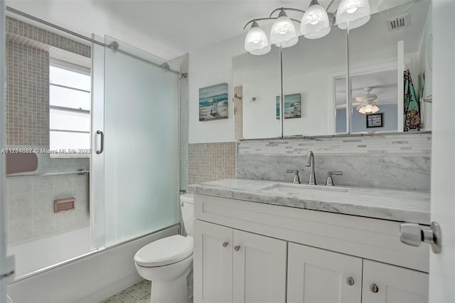 full bathroom featuring toilet, vanity, ceiling fan, decorative backsplash, and enclosed tub / shower combo