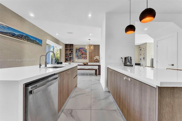 kitchen with stainless steel dishwasher, sink, hanging light fixtures, and an inviting chandelier