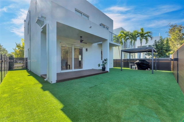 back of house with ceiling fan, a yard, and a balcony