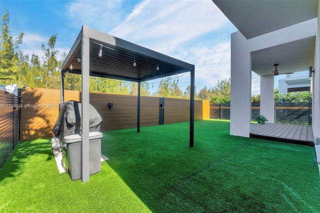 view of yard with a wooden deck and ceiling fan