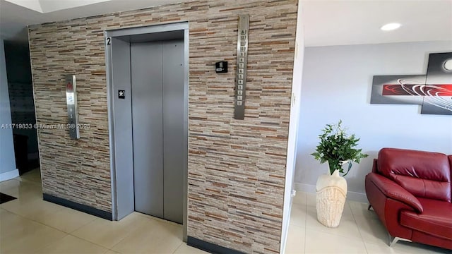 interior space featuring elevator and light tile patterned floors