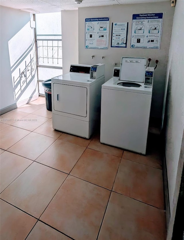 washroom with washer and dryer, light tile patterned floors, and a textured ceiling