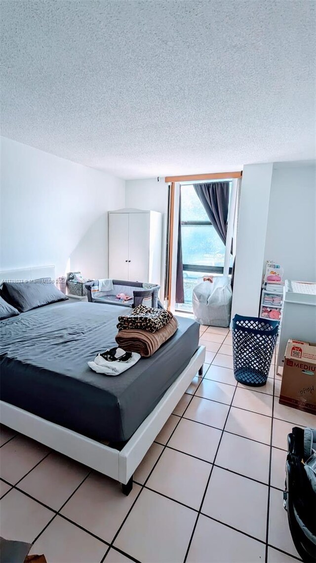 bedroom featuring a textured ceiling and light tile patterned flooring