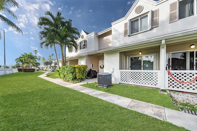 view of front of property featuring a front lawn and cooling unit