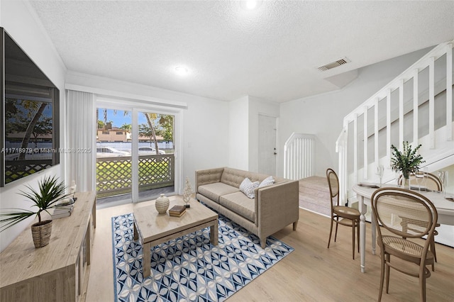 living room featuring light hardwood / wood-style floors and a textured ceiling