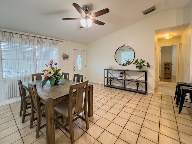 dining room featuring ceiling fan, light tile patterned floors, and vaulted ceiling