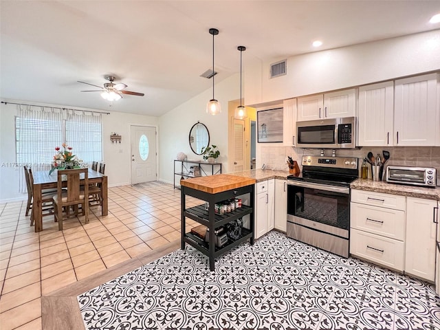 kitchen with white cabinets, ceiling fan, backsplash, and appliances with stainless steel finishes