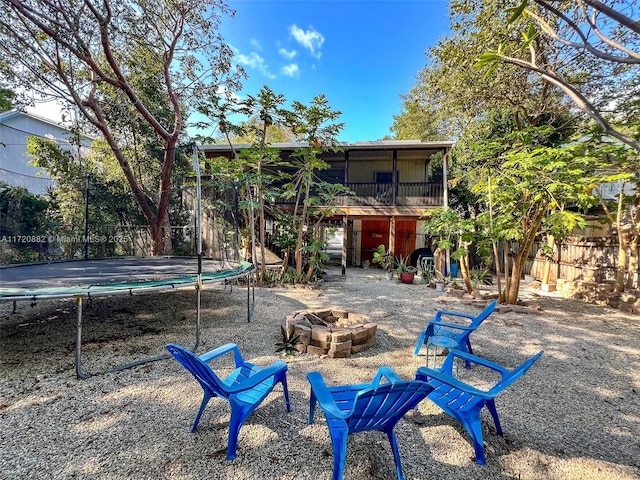 view of yard featuring a fire pit and a trampoline