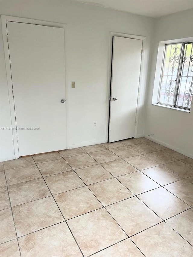 unfurnished bedroom featuring light tile patterned flooring