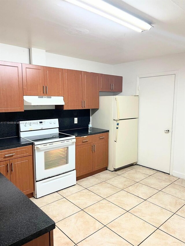7801 NW 6th Ave, Miami, FL 33150 - kitchen featuring white appliances, under cabinet range hood, dark countertops, decorative backsplash, and light tile patterned flooring