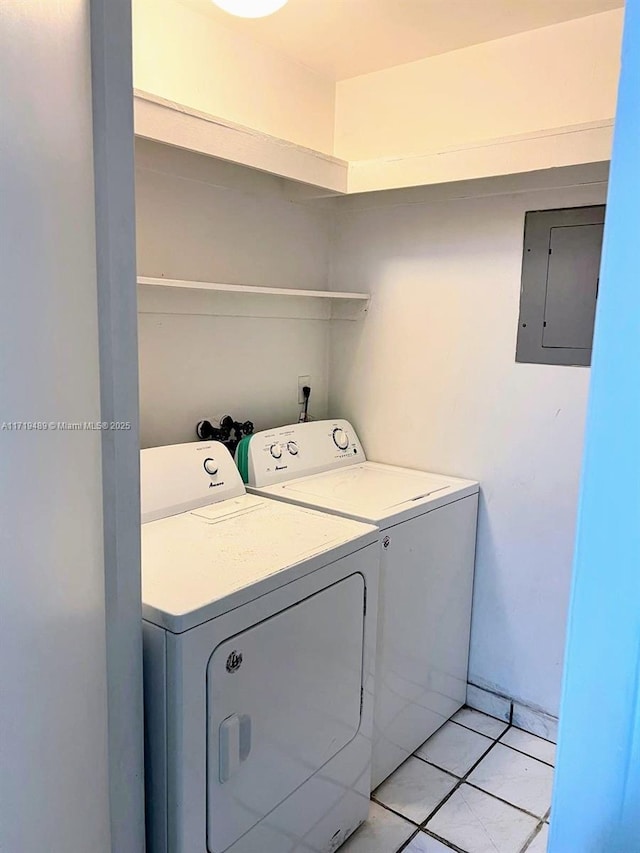 clothes washing area featuring washing machine and clothes dryer, light tile patterned floors, and electric panel