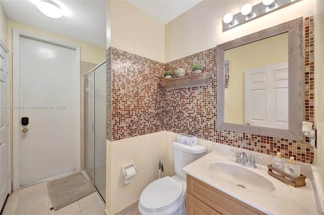 bathroom with tile patterned flooring, vanity, toilet, and an enclosed shower