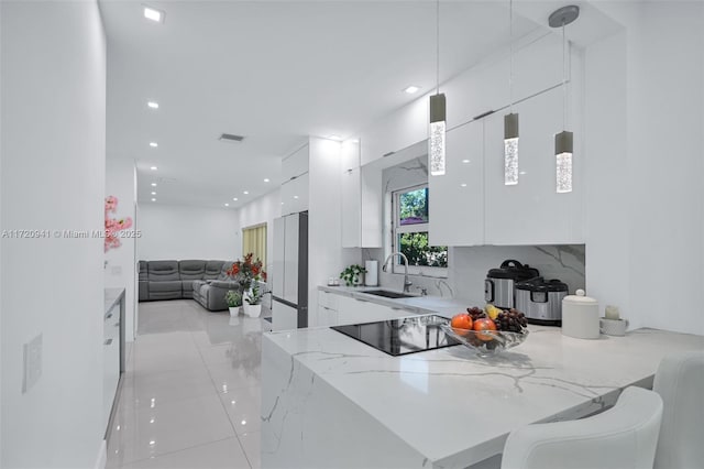 kitchen featuring white cabinets, pendant lighting, kitchen peninsula, and sink