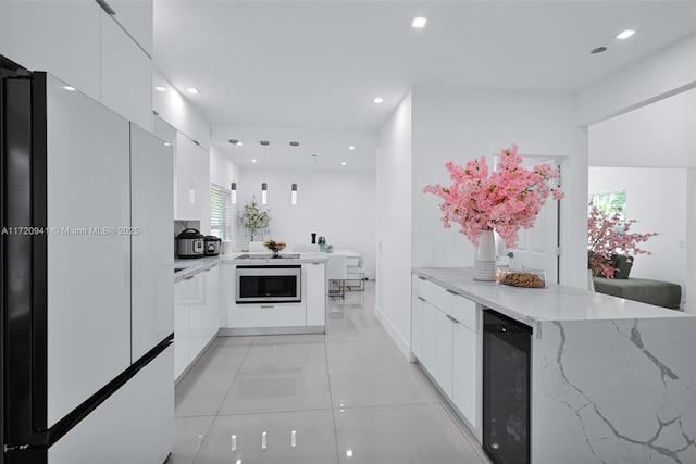 kitchen featuring white cabinetry, hanging light fixtures, wine cooler, white refrigerator, and light tile patterned flooring