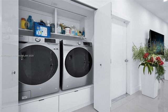 washroom featuring light tile patterned floors and washing machine and dryer