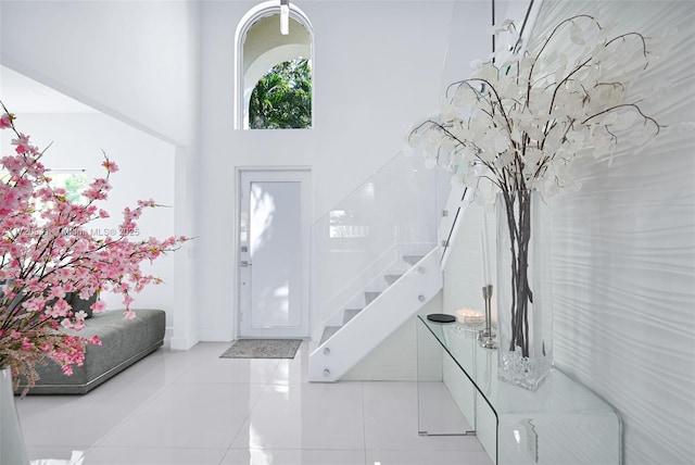 foyer with a towering ceiling and light tile patterned floors