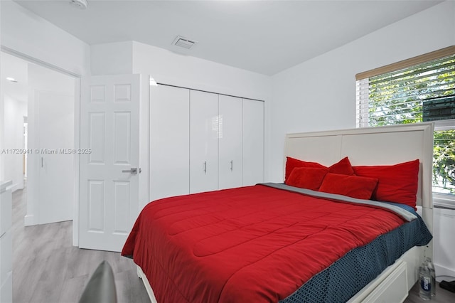 bedroom with a closet and light hardwood / wood-style flooring