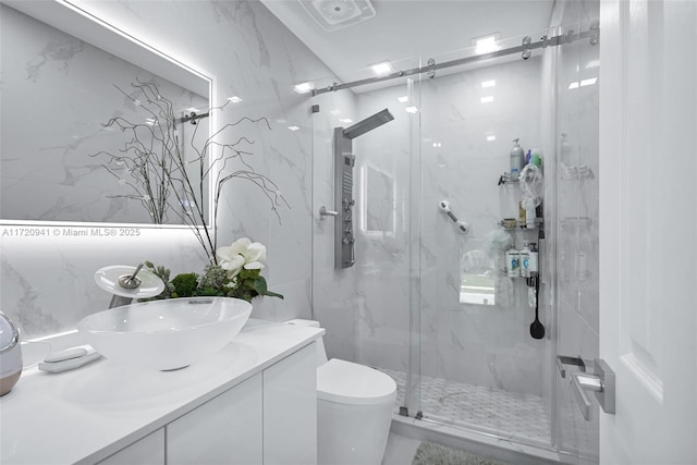 bathroom with vanity, toilet, and a shower with shower door