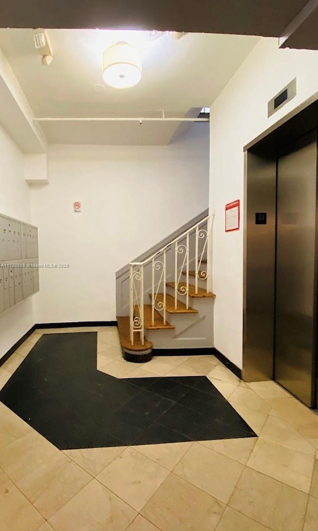 interior space featuring tile patterned floors, mail boxes, and elevator