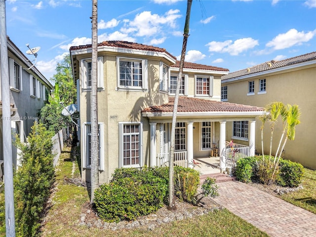 mediterranean / spanish home featuring a porch