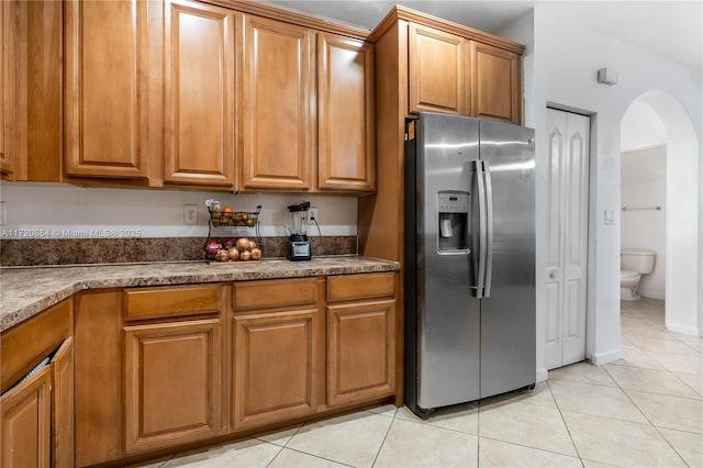 kitchen with light tile patterned floors and stainless steel refrigerator with ice dispenser