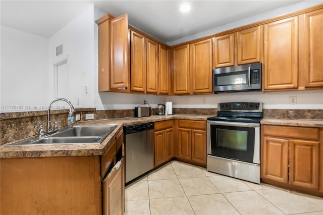 kitchen with sink, light tile patterned floors, and stainless steel appliances