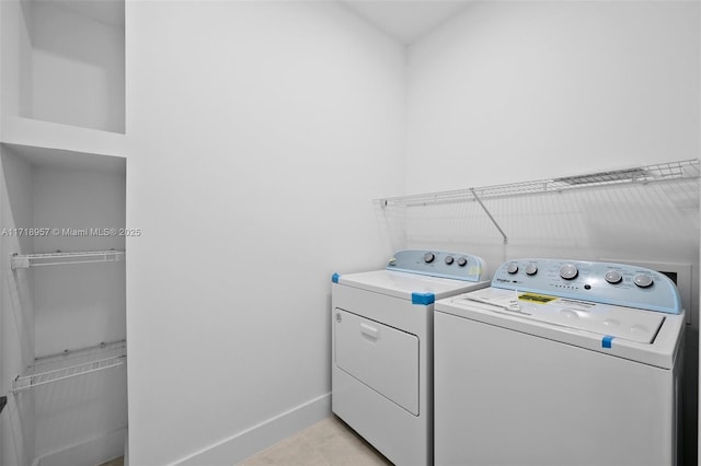 laundry room featuring light tile patterned floors and washer and dryer