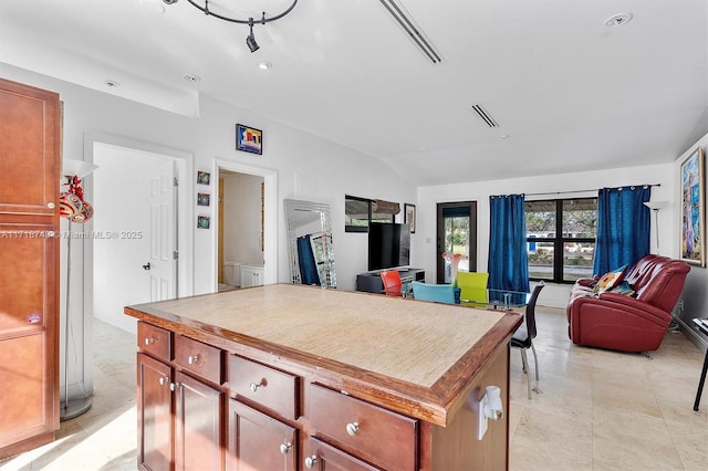 kitchen featuring lofted ceiling, visible vents, open floor plan, and a center island