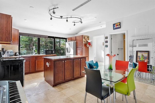 100 NE 51st St, Oakland Park, FL 33334 - kitchen with electric range, decorative backsplash, stainless steel fridge, and a center island