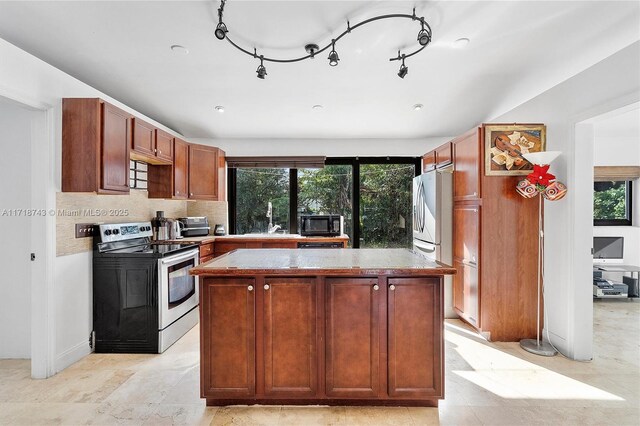 kitchen featuring a wealth of natural light, a kitchen island, and stainless steel appliances