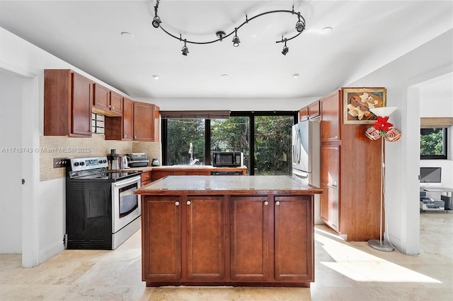 100 NE 51st St, Oakland Park, FL 33334 - kitchen with appliances with stainless steel finishes, light countertops, backsplash, and a center island