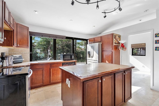 100 NE 51st St, Oakland Park, FL 33334 - kitchen with lofted ceiling, a sink, light countertops, appliances with stainless steel finishes, and a center island