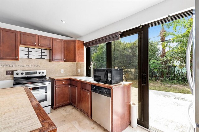 kitchen with backsplash, sink, and appliances with stainless steel finishes