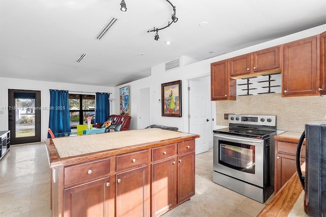 kitchen with stainless steel electric stove, tasteful backsplash, and a center island