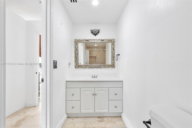 bathroom featuring walk in shower, vanity, and toilet