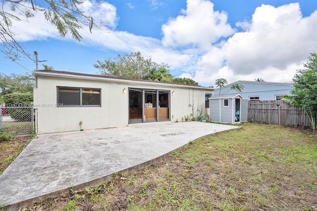 100 NE 51st St, Oakland Park, FL 33334 - back of property featuring a patio, a shed, an outdoor structure, and fence