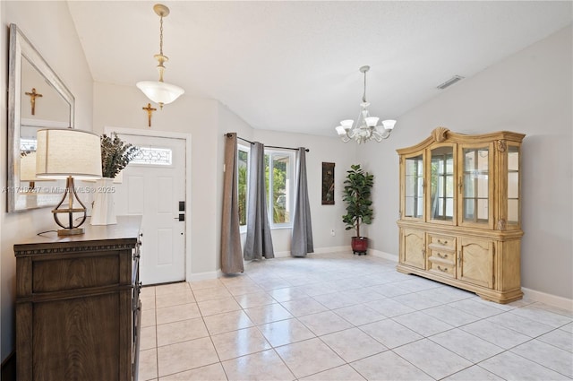 entryway with light tile patterned floors and an inviting chandelier