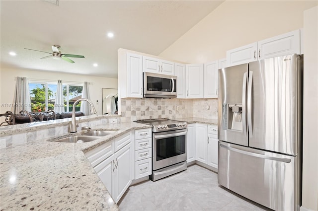 kitchen with decorative backsplash, white cabinets, and appliances with stainless steel finishes