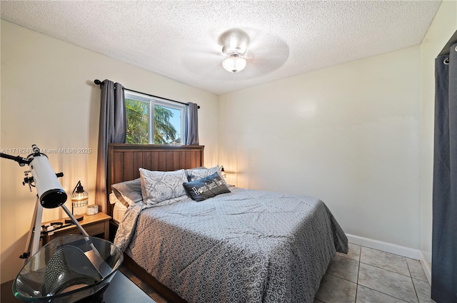 bedroom with light tile patterned floors, a textured ceiling, and ceiling fan