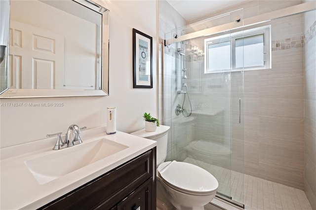 bathroom with a shower with door, vanity, and toilet