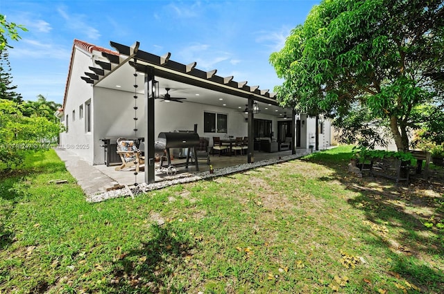 rear view of property featuring a yard, a patio, and ceiling fan