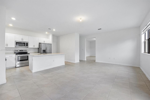 kitchen featuring decorative backsplash, a center island, white cabinets, and appliances with stainless steel finishes