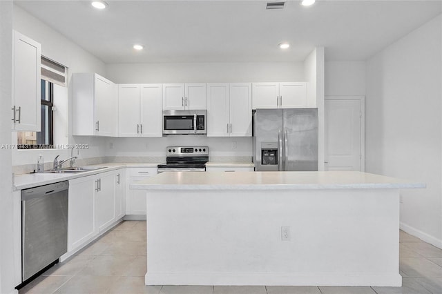 kitchen with stainless steel appliances, a center island, and white cabinets