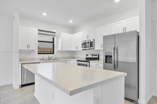 kitchen featuring white cabinetry, appliances with stainless steel finishes, a center island, and sink