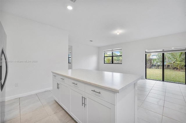 kitchen featuring white cabinetry, a center island, and light tile patterned floors