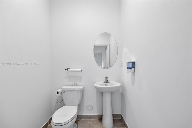 bathroom with tile patterned flooring, sink, and toilet