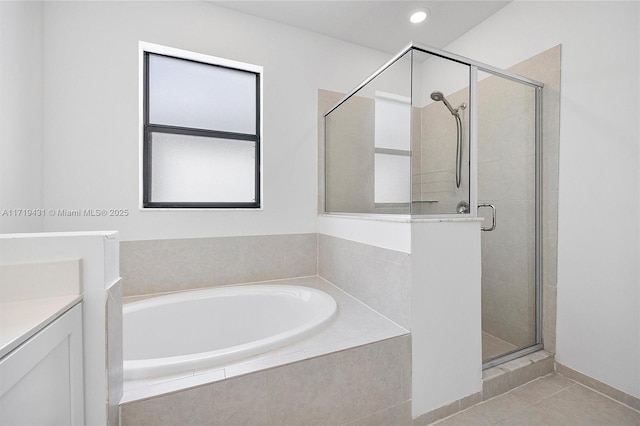 bathroom with tile patterned floors, vanity, and plus walk in shower