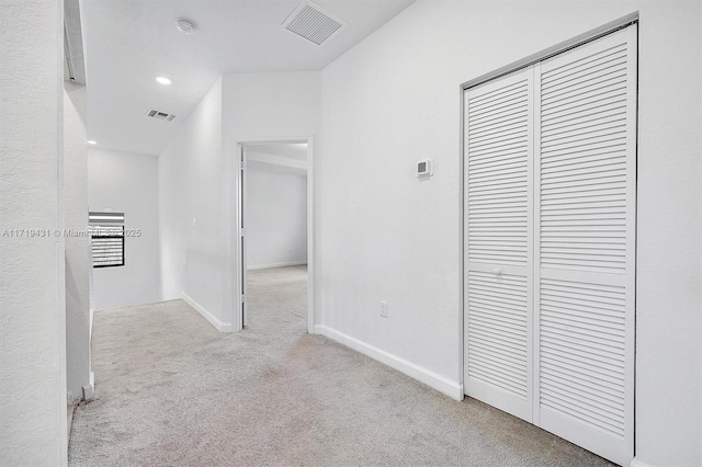 hallway featuring light colored carpet