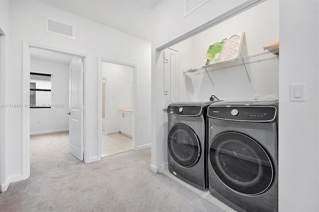 clothes washing area featuring light colored carpet and washing machine and clothes dryer